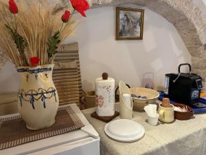 a table with a vase with flowers and plates on it at Trullo Delle Sorelle in Alberobello