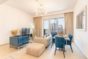 a living room with a couch and a table with chairs at Creek Horizon - 2BR Apartment - Allsopp&Allsopp in Dubai