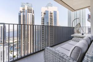 a balcony with chairs and a view of the city at Creek Horizon - 2BR Apartment - Allsopp&Allsopp in Dubai