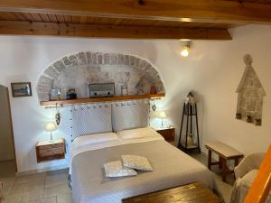 a bedroom with a large bed with a brick wall at Trullo Delle Sorelle in Alberobello