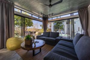 a living room with a couch and a table at Pahili Pool Villas - SHA Plus in Ko Tao