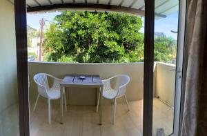 a table and chairs on the balcony of a house at Beautique Studios Lot 78 in La Gaulette
