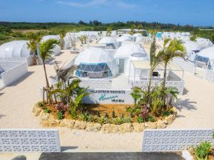 a group of domes on a beach with palm trees at GLAMTECH RESORTS HEAVEN in Miyako Island