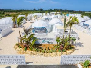 un gruppo di cupole su una spiaggia con palme di GLAMTECH RESORTS HEAVEN a Miyakojima