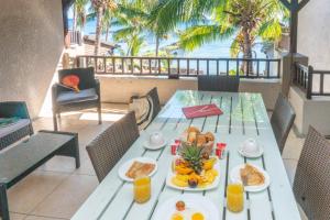 a table with breakfast food on the balcony of a resort at Bel Azur Beachfront Suites and Penthouses by LOV in Trou aux Biches
