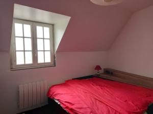 a bedroom with a red bed and a window at Maison de vacances à la plage in Saint-Nic