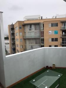 - Balcón con mesa y edificio en Hermoso Duplex en Chorrillos, en Lima