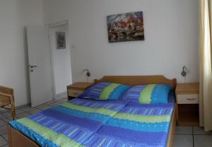 Schlafzimmer mit einem Bett mit einer blauen und grünen Bettdecke in der Unterkunft Casa Svjetlana in Orebić