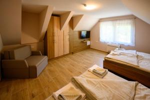 a large room with two beds and a chair at Nándi Jakuzzis Vendégház in Gyomaendrőd +32 photos