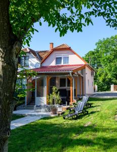 una casa con dos sillas de jardín en el patio en Nándi Vendégház, en Gyomaendrőd