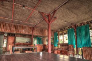 een eetkamer met een tafel en groene gordijnen bij Bello Ethnic Lombok in Tetebatu