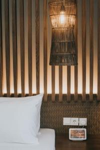 uma cama com uma cabeceira de madeira e um candeeiro em The Ning Resort Ubud em Ubud