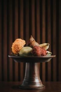 a plate of fruits and vegetables on a table at The Ning Resort Ubud in Ubud