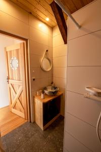 La salle de bains est pourvue d'un lavabo, d'un miroir et d'une porte. dans l'établissement Agroturystyka BRYGADZIAKI, à Charbielin