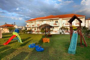 a yard with playground equipment in front of a building at Akis Studios Alykes in Alykes