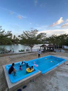 un grupo de personas jugando en una piscina en Akram Homestay en Kota Bharu