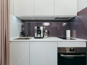 a kitchen with a sink and a coffee maker at Atlant luxury VIOLET Apart on Golovna стильні апартаменти поряд з ТЦ ДЕПОТ БЕЗКОНТАКТНЕ ЗАСЕЛЕННЯ in Chernivtsi