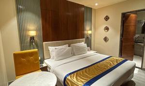 ein Hotelzimmer mit einem großen Bett und zwei Stühlen in der Unterkunft FabHotel Prime The Wish in Jaipur