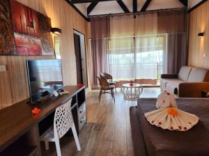 The Crow's Nest Resort Fiji في كوروتوغو: غرفة معيشة بها أريكة وتلفزيون