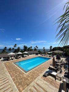 una grande piscina con sedie e ombrelloni di The Crow's Nest Resort Fiji a Korotogo