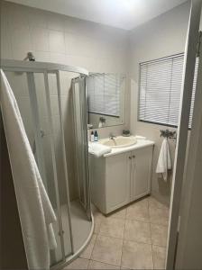 a bathroom with a shower and a sink at Grace Gardens - Grace in Pretoria