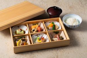 una scatola di legno riempita con diversi tipi di alimenti di The Hotel Seiryu Kyoto Kiyomizu - a member of the Leading Hotels of the World- a Kyoto