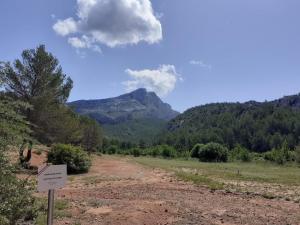 a sign on a dirt road with a mountain in the background at Chambre d hôte Entre Cigale et Pagnol in Peypin