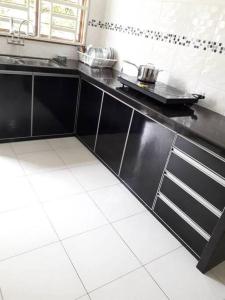 a kitchen with a black counter top in a kitchen at Cozy Homestay in Central Pokok Sena in Pokok Sena