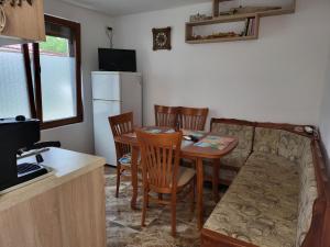eine Küche mit Tisch und Stühlen und einer Couch in der Unterkunft Вила за гости Даная-Фар Шабла in Tyulenovo
