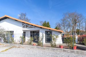 une maison blanche avec une clôture devant elle dans l'établissement Landescape Océan, Lacs et Forêt., à Biscarrosse