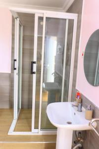 a bathroom with a sink and a glass shower at The Red Container-Off Grid in Ngong