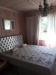 um quarto com uma cama grande e uma janela em Apartament Olivija em Jūrmala