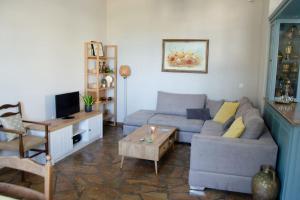 a living room with a couch and a table at m͟͞a͟͞t͟͞a͟͞t͟͞h͟͞i͟͞a͟͞ GuestHouse Tinos in Triandáros