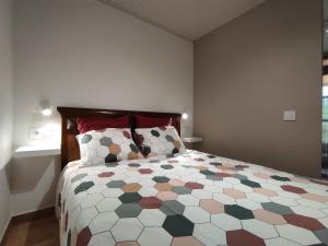 1 dormitorio con 1 cama grande y edredón colorido en Allotjament Rural Solsona, en Solsona