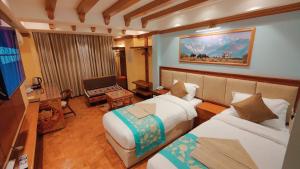 una camera d'albergo con due letti e una televisione di Sherpa Home Hotel a Kathmandu