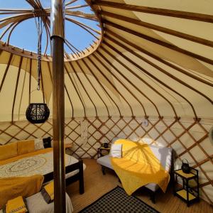 um quarto com uma tenda com uma cama e uma janela em Bronfelen Yurt em Cynghordy
