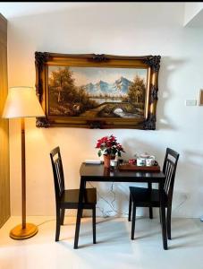 a table with two chairs and a picture on the wall at Beautiful 1BR balcony w/65UHDTV Wifi Netflix, pool in Manila