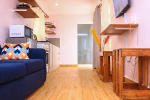a living room with a blue couch and a wooden floor at The Red Container-Off Grid in Ngong +35 photos