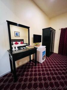 a hotel room with a desk and a mirror at DANA HOTEL in Sharjah