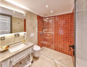 a bathroom with a shower and a toilet and a sink at Jasmine Otel in Kaş