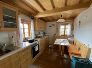 a kitchen with wooden cabinets and a table in it at Andi's Berghütte in Weitensfeld