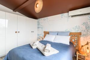 a bedroom with a blue bed with towels on it at Landescape Océan, Lacs et Forêt. in Biscarrosse