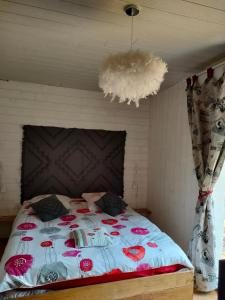 1 dormitorio con cama con edredón y techo en OFILDLEAU, en Sillans-la Cascade