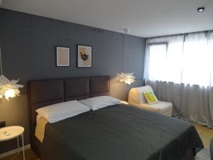 a bedroom with a bed and a chair and a window at Modern Small House with a Terrace in Split