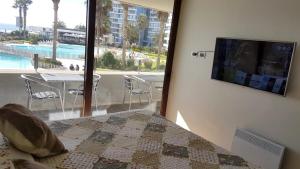 a bedroom with a bed and a view of a pool at Jardin del Mar SPA & Enjoy in Coquimbo