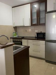a kitchen with white cabinets and a stainless steel refrigerator at Apartments Domane Nenad in Neum