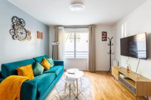 uma sala de estar com um sofá azul e uma mesa em Cosy appart entre Paris et Disneyland em Villiers-sur-Marne