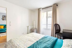 1 dormitorio con cama, escritorio y ventana en Cosy appart entre Paris et Disneyland en Villiers-sur-Marne