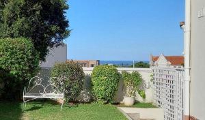 a white bench sitting in a yard next to a fence at Innes Road Durban Accommodation Private Double Room with Private Bathroom in Durban