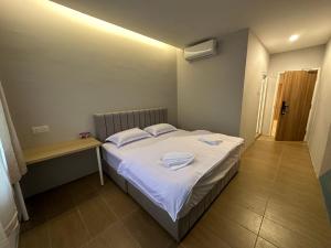 een kleine slaapkamer met een bed met handdoeken erop bij A1 Hotel Sungai Petani in Sungai Petani